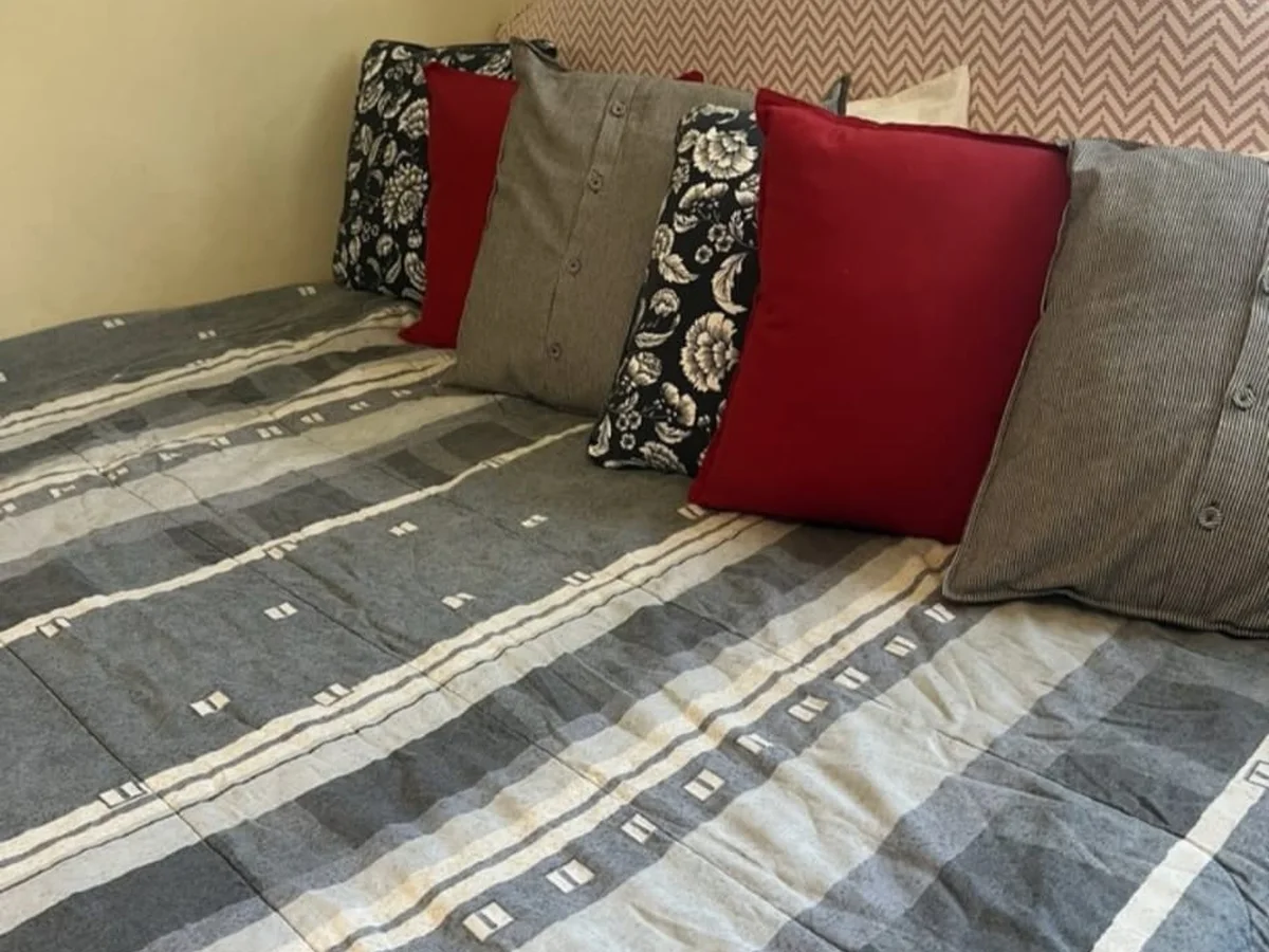 Made bed with fresh linens in a cleaned bedroom